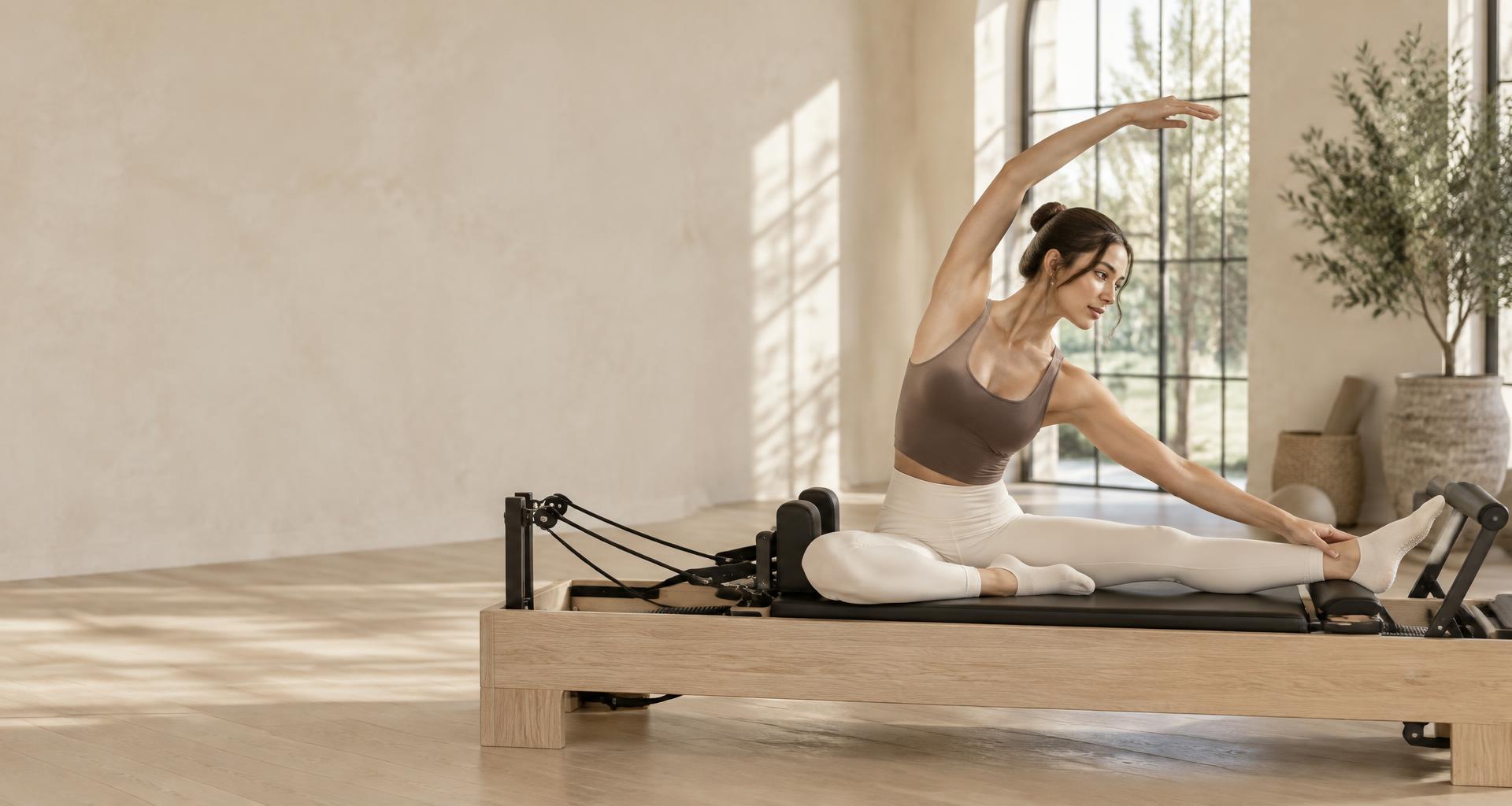 A quiet moment of stretching in a sunlit Pilates studio